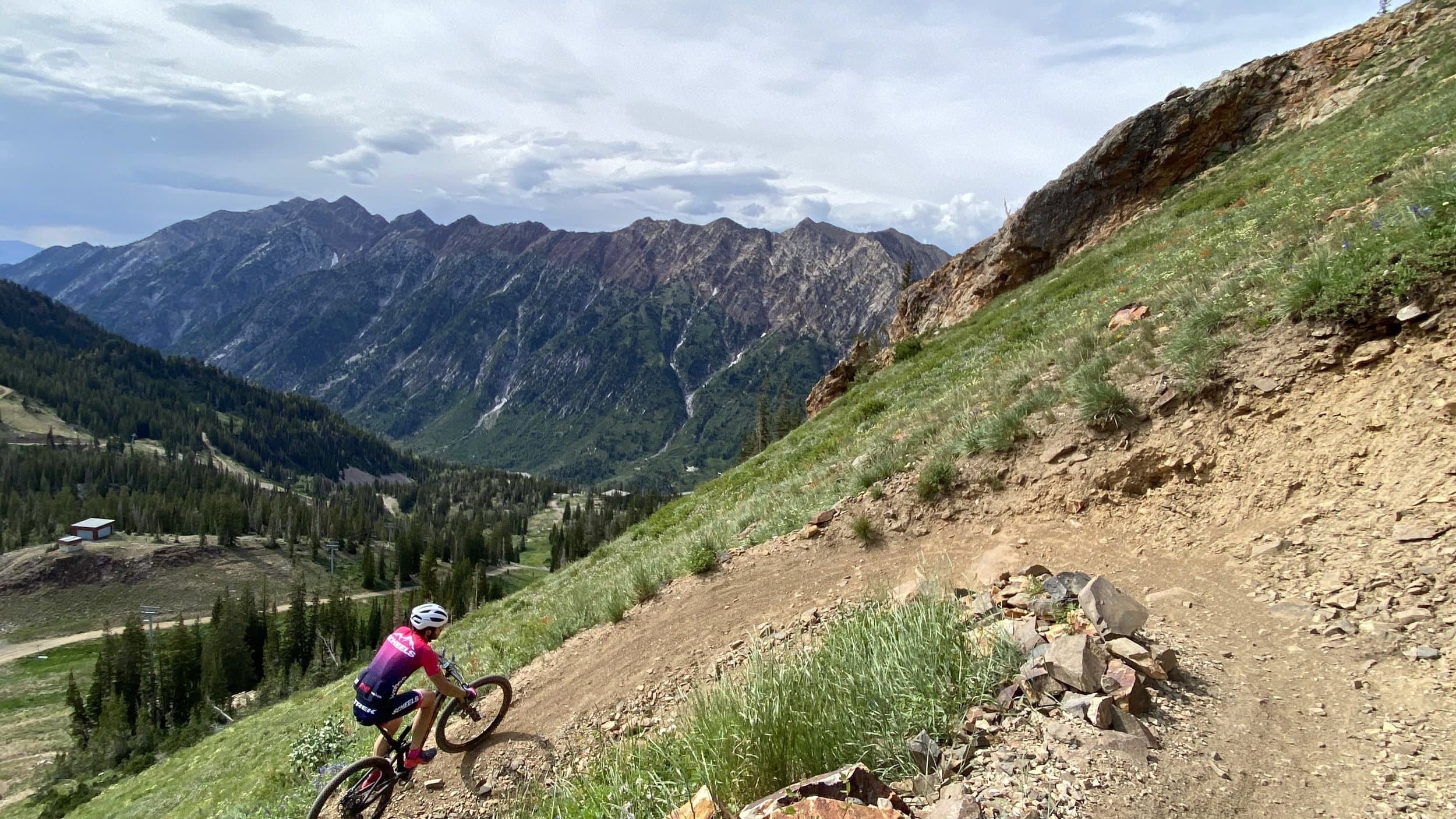 Mountain biker climbing a high alpine trail above a Utah canyon
