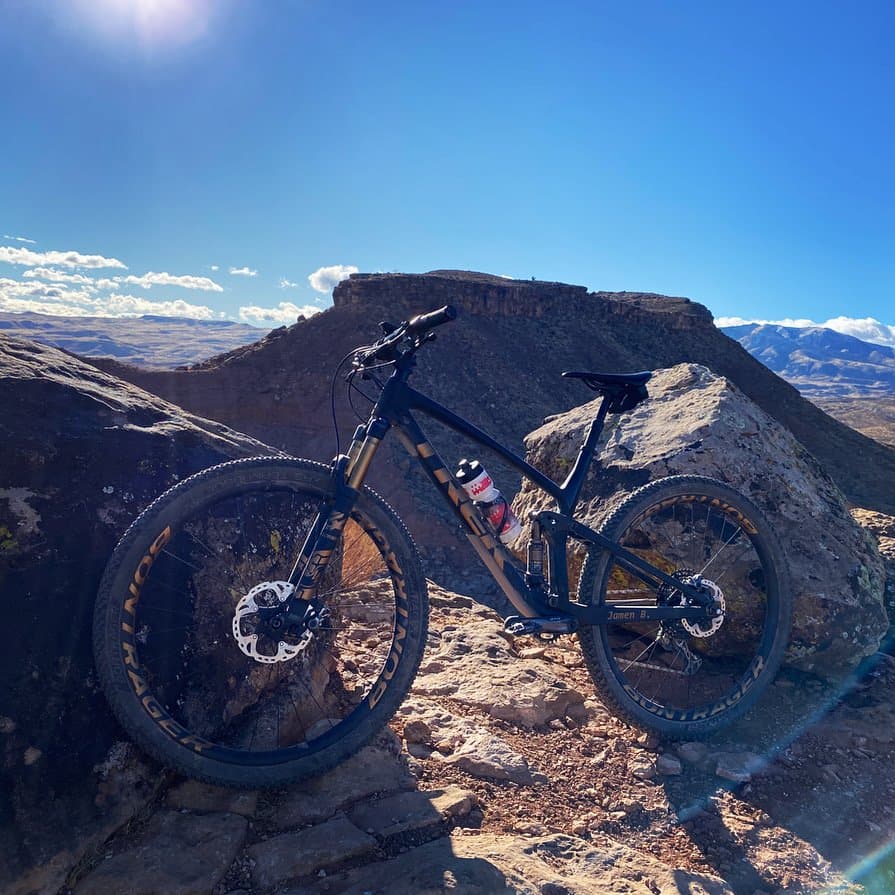 Mountain bike on slickrock with desert mesas behind