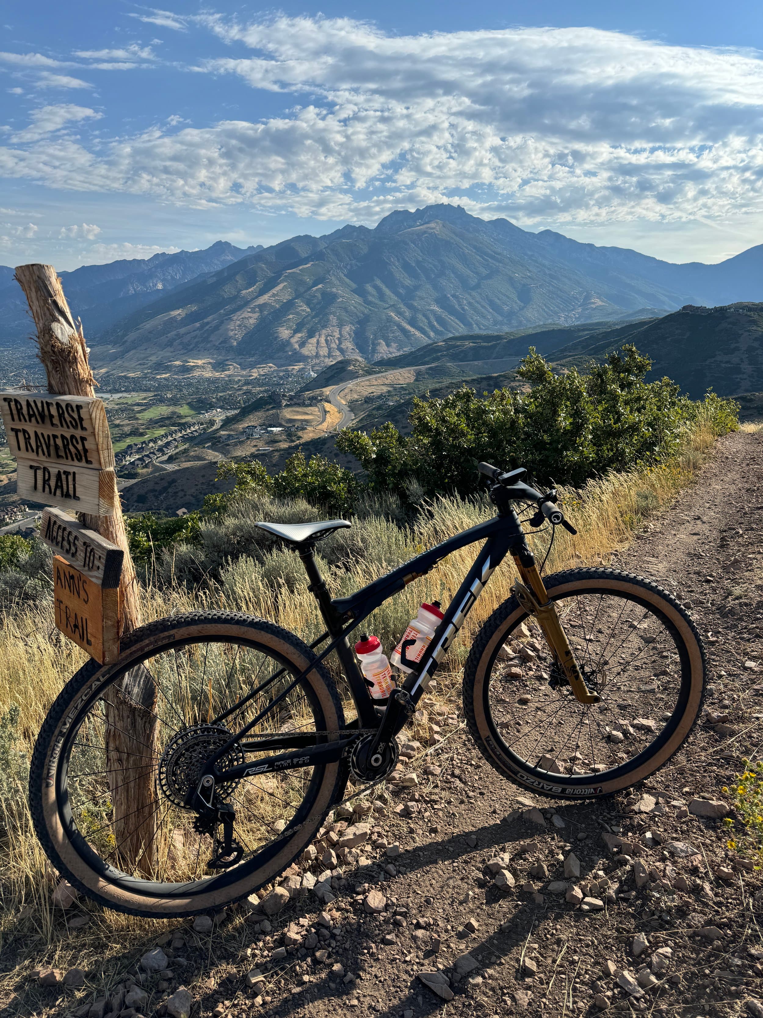 Trek mountain bike leaning on the Traverse Trail signpost above the valley